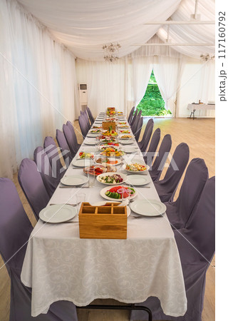 festive table set with Caesar salads, beets, fruit plate without people 117160792