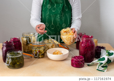Woman fermenting fresh vegetables 117161974