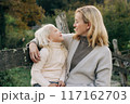 Mom with her little daughter on a walk outside on an autumn day.	 117162703