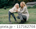 Cheerful carefree mother and little daughter on a walk in the farm.	 117162708