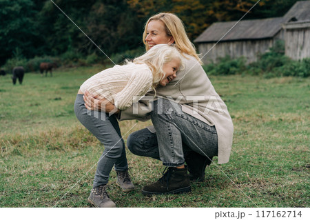 Loving mother tickles her laughing adorable curly little daughter. Loving mother tickles her laughing adorable curly little daughter. 117162714