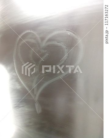 Heart-shaped steam pattern on glass with soft light background, symbolizing love and romance. Heart-shaped steam pattern on glass with soft light background, symbolizing love and romance. 117163272