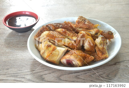 roasted chop chicken meat wing and leg on plate dipping with spicy sauce roasted chop chicken meat wing and leg on plate dipping with spicy sauce 117163992