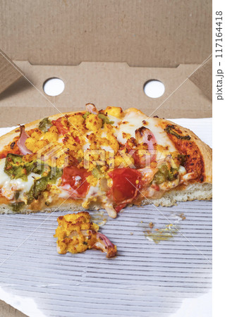 Closeup of leftover pizza in cardboard box on white background. 117164418