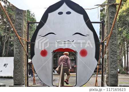 福岡県築上町にある越路日吉神社節分祭の大お多福をくぐる人 117165623