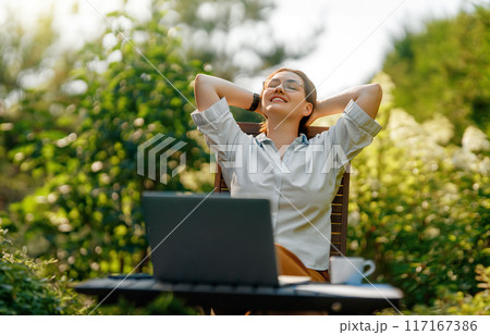 woman working on laptop in summer morning woman working on laptop in summer morning 117167386