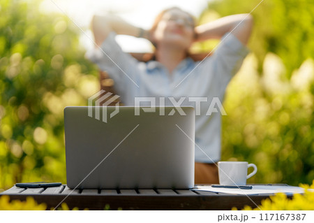 woman working on laptop in summer morning woman working on laptop in summer morning 117167387