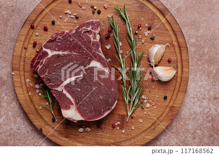 fresh raw rib eye steak, on a cutting board, top view, 117168562