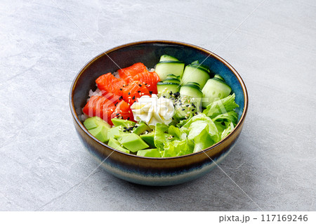 Hawaiian salmon poke bowl with avocado, Top view, gray background Hawaiian salmon poke bowl with avocado, Top view, gray background 117169246