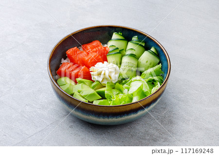Hawaiian salmon poke bowl with avocado, Top view, gray background Hawaiian salmon poke bowl with avocado, Top view, gray background 117169248