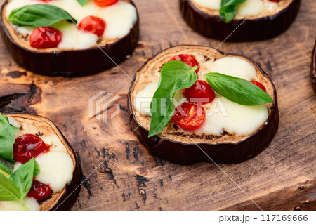 Italian mini pizza . Aubergine (eggplant ) with mozzarella cheese and basil . On rustic background Italian mini pizza . Aubergine (eggplant ) with mozzarella cheese and basil . On rustic background 117169666