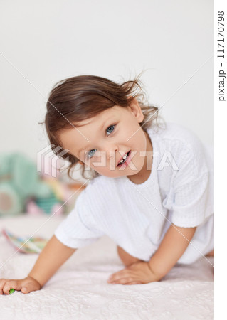 smiling cute little baby girl in white t-shirt playing in her room smiling cute little baby girl in white t-shirt playing in her room 117170798