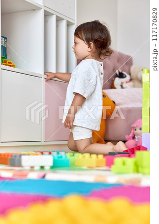 cute baby girl playing with colorful toys bricks in white bedroom cute baby girl playing with colorful toys bricks in white bedroom 117170829