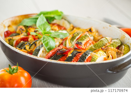 prepared baked zucchini and tomatoes in circles in a ceramic form, vegetable snack prepared baked zucchini and tomatoes in circles in a ceramic form, vegetable snack 117170974