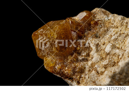 Macro stone Grossular mineral on a black background 117172502