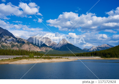 An incredible view of a natural mountain lake on a sunny summer day against the backdrop of the rocky mountains of Alberta in Canada. 117172928