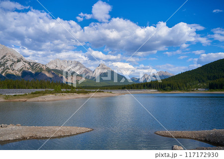 An incredible view of a natural mountain lake on a sunny summer day against the backdrop of the rocky mountains of Alberta in Canada. 117172930