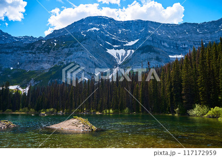 Incredibly beautiful transparent, emerald calm lake with reflection of rocky mountain on the Black Prince Cirque Trail. Majestic Canadian mountains with snow on sunny summer day in Alberta, Kananaskis Incredibly beautiful transparent, emerald calm lake with reflection of rocky mountain on the Black Prince Cirque Trail. Majestic Canadian mountains with snow on sunny summer day in Alberta, Kananaskis 117172959