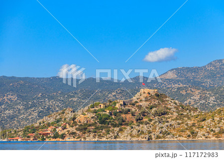 View of ancient Lycian town Simena with fortress on a mount on the coast of the Mediterranean sea in Antalya Province, Turkey 117172983