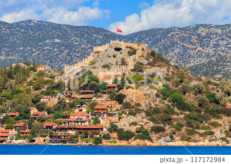 View of ancient Lycian town Simena with fortress on a mount on the coast of the Mediterranean sea in Antalya Province, Turkey 117172984