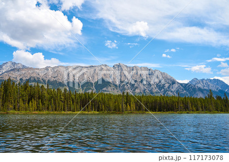 A beautiful clean, transparent mountain lake with a view of the rocky mountains in Kananaskis in the province of Alberta, Canada. A beautiful clean, transparent mountain lake with a view of the rocky mountains in Kananaskis in the province of Alberta, Canada. 117173078
