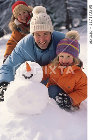 Happy family father and daughters made a snowman, winter wellness and activity 117173298