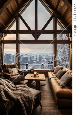 Cozy living room with sofa and panoramic window overlooking the winter mountains and forest 117173327