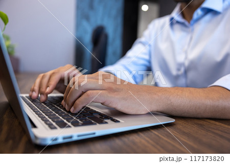 Businessman working on laptop doing data analysis in modern office Businessman working on laptop doing data analysis in modern office 117173820