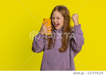 Child girl kid use mobile smartphone browsing say Wow yes found out great win good news celebrate 117174125