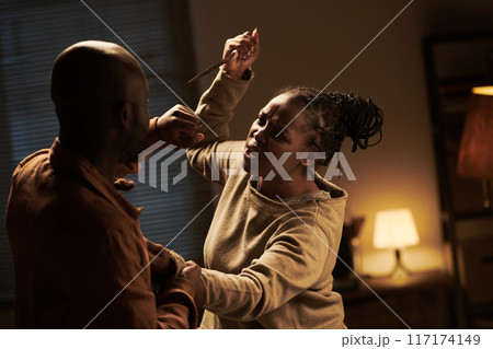 Woman attacking her husband with knife 117174149