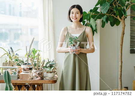 部屋で観葉植物を持つ女性 117174782