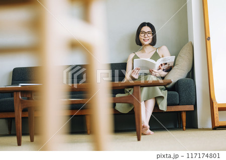 ソファーで雑誌を読む女性 117174801