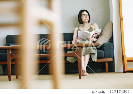 ソファーで雑誌を読む女性 117174803