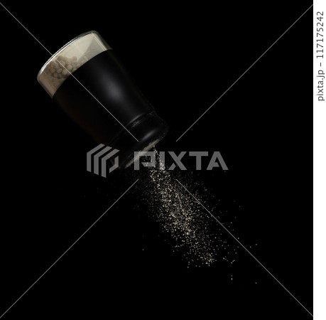 Pepper seed seasoning powder flavor falling from shaker bottle, ground pepper and seasoning powder splash in mid air. Seasoning powder shaker spice up taste of food over black background isolated Pepper seed seasoning powder flavor falling from shaker bottle, ground pepper and seasoning powder splash in mid air. Seasoning powder shaker spice up taste of food over black background isolated 117175242