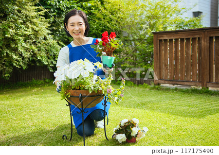 寄せ植えをする笑顔のミドル女性 117175490