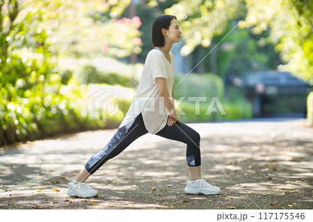 スポーツウエアでストレッチをする笑顔の若い女性 スポーツウエアでストレッチをする笑顔の若い女性 117175546