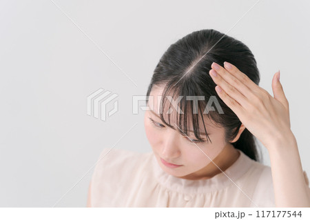 頭をおさえる若い女性 117177544