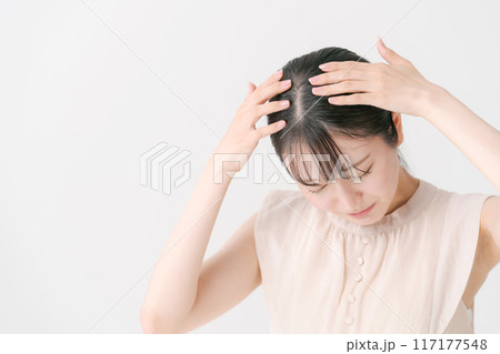頭をおさえる若い女性 117177548