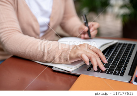 A woman pressing the Enter button to pause a video while studying an online class on her laptop. A woman pressing the Enter button to pause a video while studying an online class on her laptop. 117177615