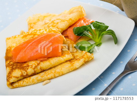 Delicious homemade crepes served with smoked salmon closeup 117178553