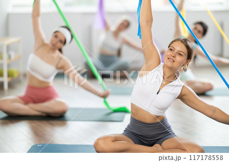 Group of young women doing pilates with band Group of young women doing pilates with band 117178558