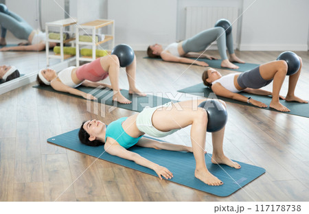 Young girls practicing bridge position with soft ball Young girls practicing bridge position with soft ball 117178738
