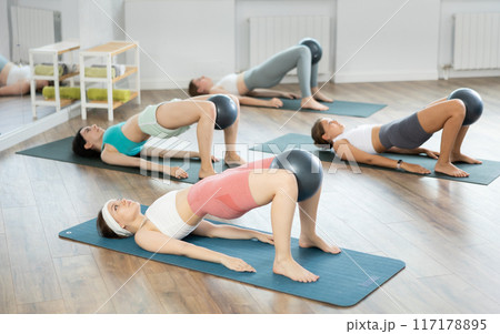 Young girls practicing bridge position with soft ball 117178895