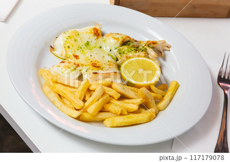 Grilled cuttlefish with fries and green sauce 117179078