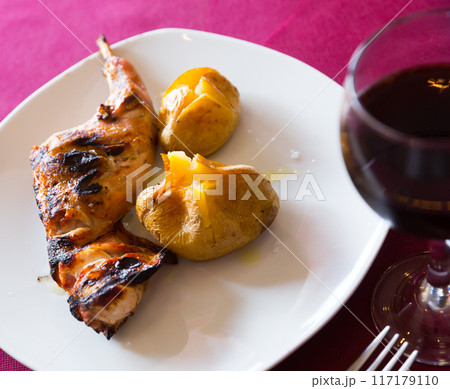 Baked in oven quarter of rabbit, served with pototoes at plate 117179110