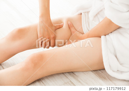 女性は太ももをマッサージしている。 117179912