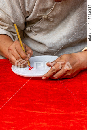 Vertical photo of human hand doing handwriting by calligraphic brush pen  117180331