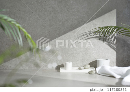 A gray-toned tile background with various props with sunlight coming through the window. A gray-toned tile background with various props with sunlight coming through the window. 117180851