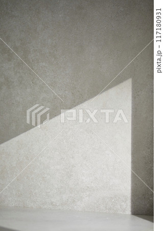 A gray-toned tile background with various props with sunlight coming through the window. 117180931