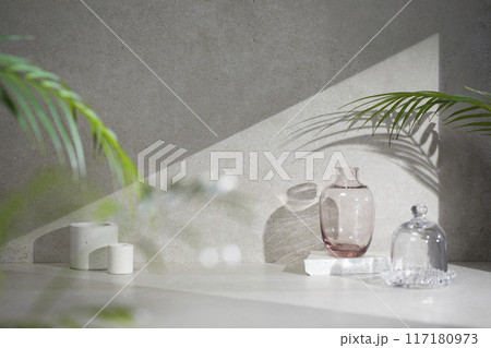 A gray-toned tile background with various props with sunlight coming through the window. A gray-toned tile background with various props with sunlight coming through the window. 117180973